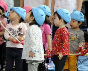 Children at Japan School Sport Festival, photo by Ari Helminen, CC 2.0 via Flicker. (Cropped)